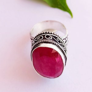 Peut inclure: Une bague en argent avec une pierre pr&eacute;cieuse rose ovale sertie dans une bande d'argent d&eacute;corative.