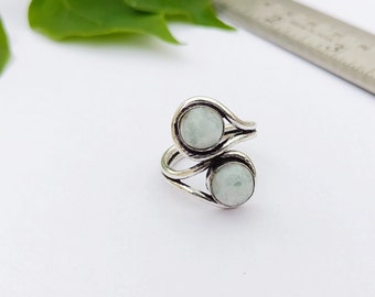 May include: A silver ring with two white stones set in a twisted band.