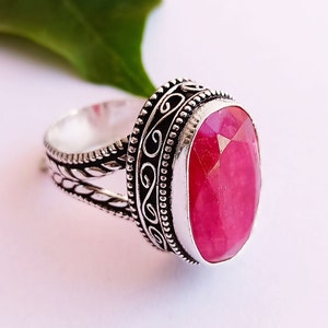 Peut inclure: Une bague en argent avec un motif orné et une grande pierre précieuse rose de forme ovale.