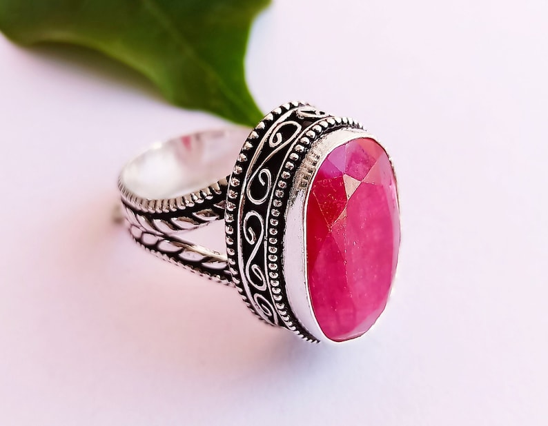 Peut inclure: Une bague en argent avec un motif orn&eacute; et une grande pierre pr&eacute;cieuse rose de forme ovale.