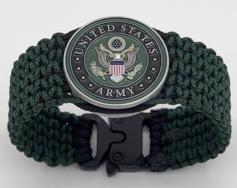 Könnte beinhalten: Ein grünes Paracord-Armband mit einer schwarzen Schnalle und einem metallischen Emblem der US-Armee. Das Emblem zeigt einen Weißkopfseeadler mit einem Schild und den Worten "United States Army".
