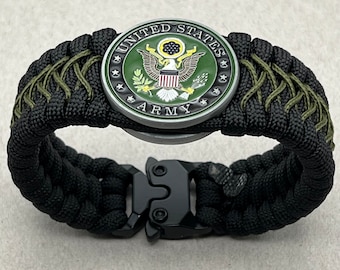 Könnte beinhalten: Schwarzes Paracord-Armband mit einem grünen und silbernen Emblem der US-Armee und einer schwarzen Schnalle.