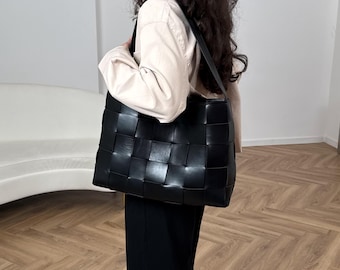 Black woven leather shoulder bag, bold panel design, structured everyday handbag, modern work accessory