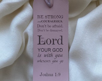 May include: A pink leather bookmark with the text "BE STRONG and COURAGEOUS. Don't be afraid. Don't be dismayed, for the Lord YOUR GOD is with you wherever you go Joshua 1:9".