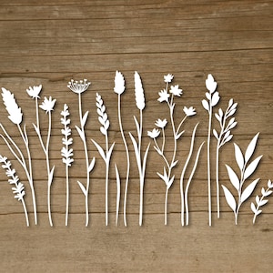 May include: A row of white silhouette cutouts of various types of flowers and grasses on a brown wood background.