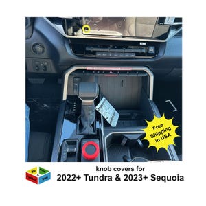 May include: Interior view of a car's console, featuring a black and silver design. A red knob cover is visible, along with the text "knob covers for 2022+ Tundra & 2023+ Sequoia." A yellow starburst graphic reads "Free Shipping in USA."