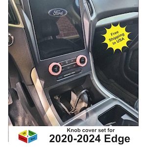 May include: Interior view of a Ford Edge dashboard with pink knob covers. The image shows the center console with the Ford logo and the text "Knob cover set for 2020-2024 Edge".