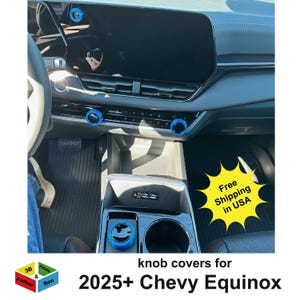 May include: Interior view of a car dashboard with blue knob covers installed. The image shows the dashboard, steering wheel, and center console. Text on the image reads "knob covers for 2025+ Chevy Equinox".