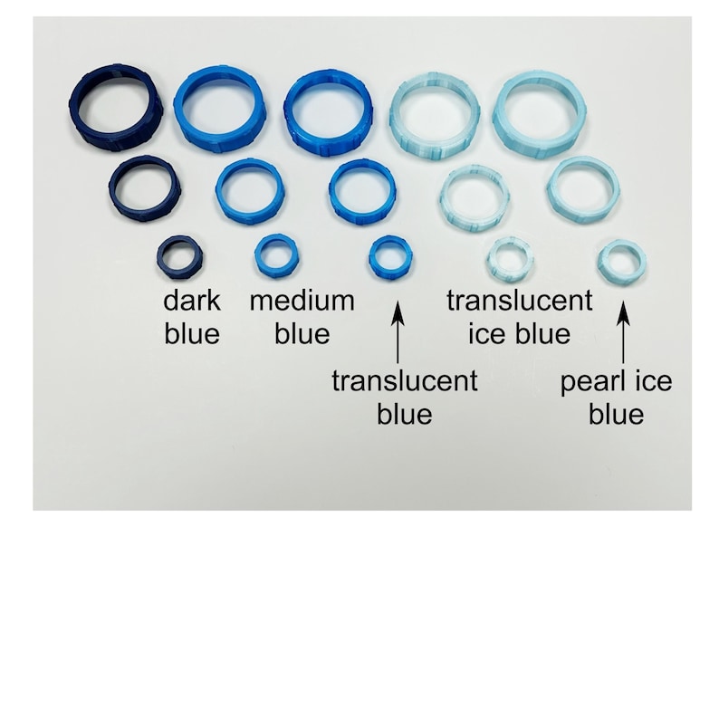 May include: A collection of blue rings in various sizes and shades, including dark blue, medium blue, translucent blue, translucent ice blue, and pearl ice blue. The text labels each color. The rings are arranged on a white surface.