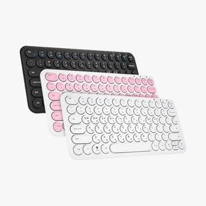 May include: Three wireless keyboards with round keys. The top keyboard is black, the middle keyboard is white with pink keys, and the bottom keyboard is white with white keys.