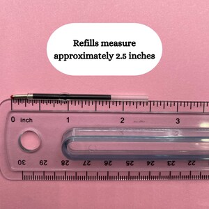 May include: A close-up of a black pen refill measured against a ruler. The refill measures 2.5 inches long. The text "Refills measure approximately 2.5 inches" is visible in the image.