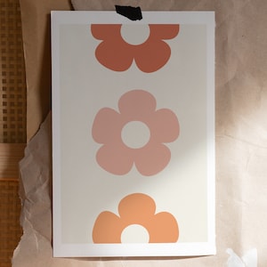 May include: A print with three stylized flowers in shades of orange, pink, and peach on a cream background.