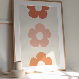 May include: A framed print with three stylized flowers in shades of orange and pink on a cream background.