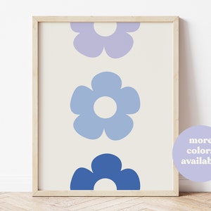 K&ouml;nnte beinhalten: Ein gerahmter Druck mit einem vertikalen Design aus drei stilisierten Blumen in Blaut&ouml;nen und Lila. Die Blumen haben einen einfachen, Retro-Look.