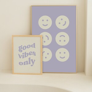 Może przedstawiać: Dwa oprawione wydruki, jeden z tekstem "good vibes only" w kolorze fioletowym na białym tle, a drugi z sześcioma r&oacute;żnymi ż&oacute;łtymi uśmiechami na jasnofioletowym tle.