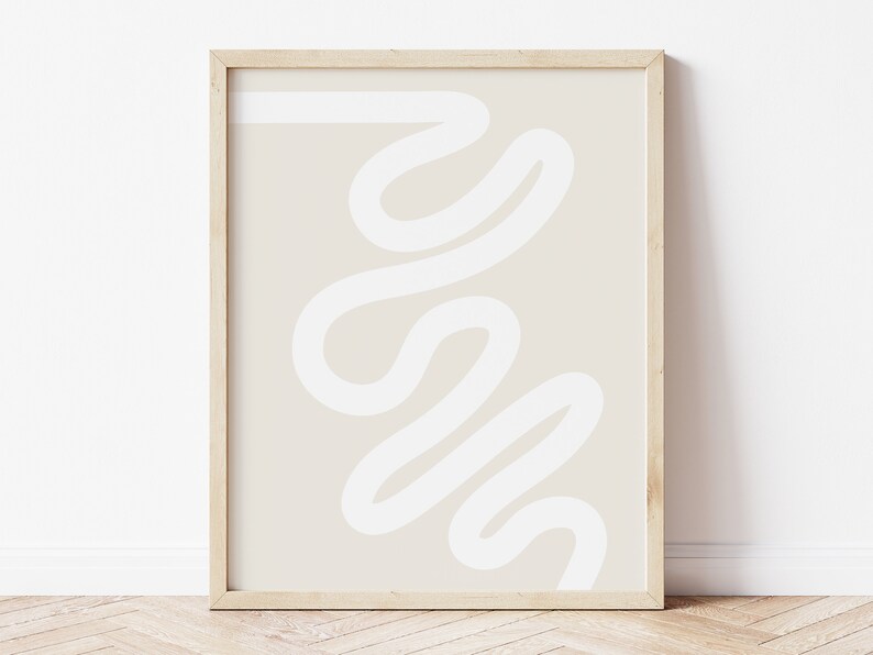 May include: A framed abstract print with a white, squiggly line design on a beige background.