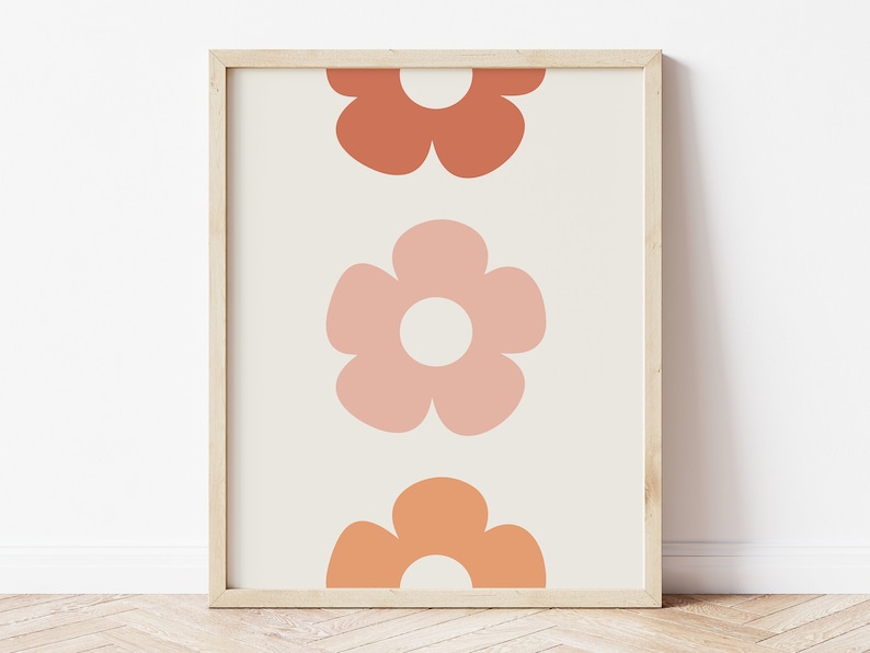 May include: A framed print with a minimalist design featuring three stylized flowers in shades of orange and pink on a cream background.