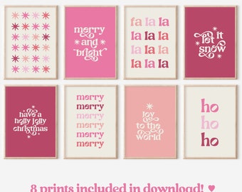 May include: Set of eight printable Christmas-themed posters with pink and white text on a cream background. The posters feature phrases like "Merry and Bright", "Let it Snow", "Joy to the World", and "Ho Ho Ho".