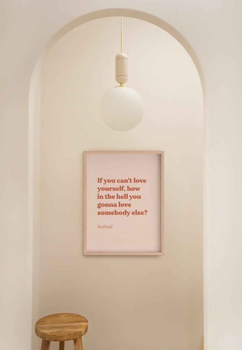 May include: A framed print with a pink background and a quote in brown text that reads "If you can't love yourself, how in the hell you gonna love somebody else?" The quote is attributed to RuPaul.