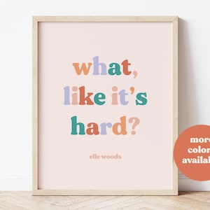 May include: A framed print with a pink background and the text "what, like it's hard?" in colorful letters. The text is attributed to "elle woods".