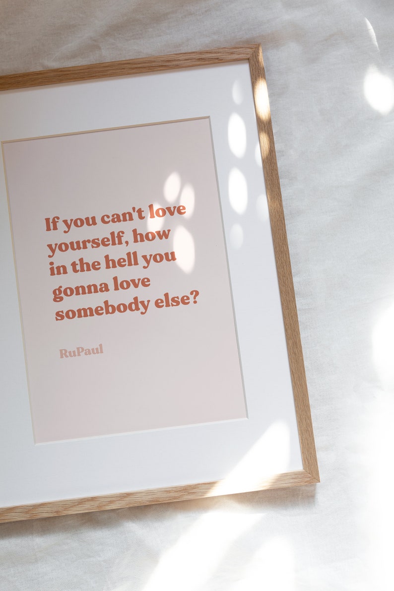 May include: A framed print with a peach background and a quote in orange text: "If you can't love yourself, how in the hell you gonna love somebody else?" - RuPaul