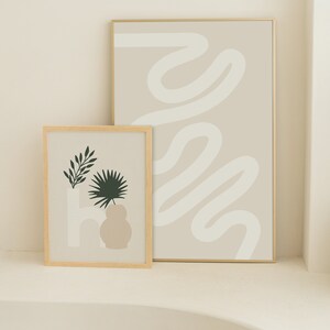 May include: Two framed prints with minimalist abstract designs. The print on the left features a stylized plant in a vase with a beige background. The print on the right features a white abstract line design on a beige background.
