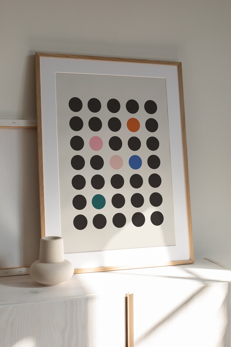 Puede incluir: Una impresi&oacute;n enmarcada con un dise&ntilde;o minimalista que presenta una cuadr&iacute;cula de c&iacute;rculos negros con toques de color, incluyendo naranja, rosa, azul y turquesa.
