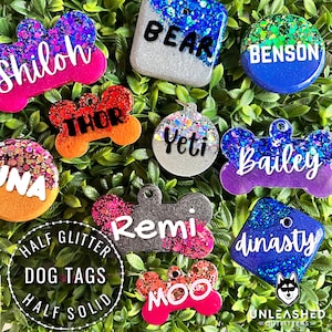 May include: A collection of colorful, glittery dog tags with various names, including Shiloh, Thor, Yeti, Bailey, Remi, Dynasty, and Moo. The tags are made with half glitter and half solid resin, and are available in a variety of shapes and sizes.