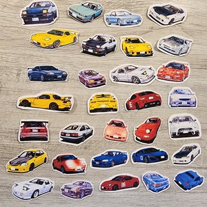 May include: A collection of 30 colorful car stickers featuring various makes and models of Japanese sports cars. The stickers are printed on white paper and have a glossy finish.