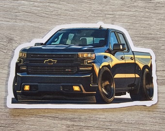 Puede incluir: Camioneta Chevrolet Silverado negra con una franja amarilla a lo largo del lateral. La camioneta tiene una parrilla negra y ruedas negras.