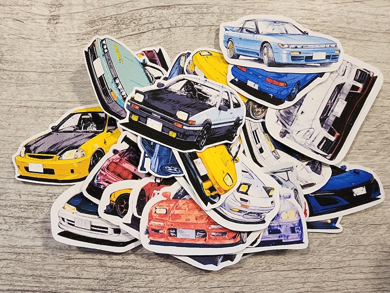 May include: A collection of colorful car stickers featuring various makes and models. The stickers are printed on white paper and have a glossy finish.