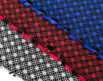 May include: Three fabric swatches with geometric patterns. The top swatch is blue with a black pattern, the middle swatch is red with a black pattern, and the bottom swatch is black and white.