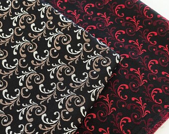 May include: Two fabric swatches with a black background and a repeating pattern of stylized leaves. One swatch has a red and burgundy leaf pattern, the other has a brown and white leaf pattern.