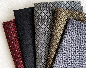 May include: Five fabric swatches with a geometric pattern. The swatches are in shades of red, black, gray, gold, and purple.