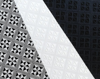 May include: Black and white patterned fabric with a geometric design. The fabric is divided diagonally with a black section on the top right and a white section on the bottom left.