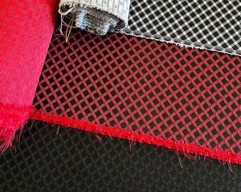 May include: Three rolls of fabric with different patterns. The first roll is a bright red fabric with a small diamond pattern. The second roll is a gray fabric with a small white diamond pattern. The third roll is a black and white checkered fabric.