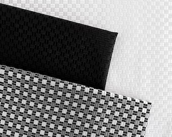 May include: A black and white checkered fabric with a black fabric underneath. Both fabrics have a textured woven pattern.