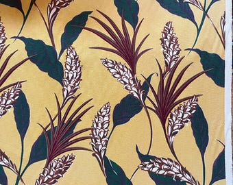 May include: Close-up of a fabric with a repeating botanical pattern. The design features stylized plants with dark green leaves, burgundy stems, and white and brown flower-like clusters, set against a golden-yellow background.