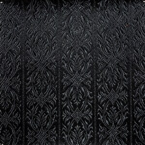 May include: Black fabric with a raised, embossed damask pattern. The pattern is a repeating design of stylized leaves and swirls.