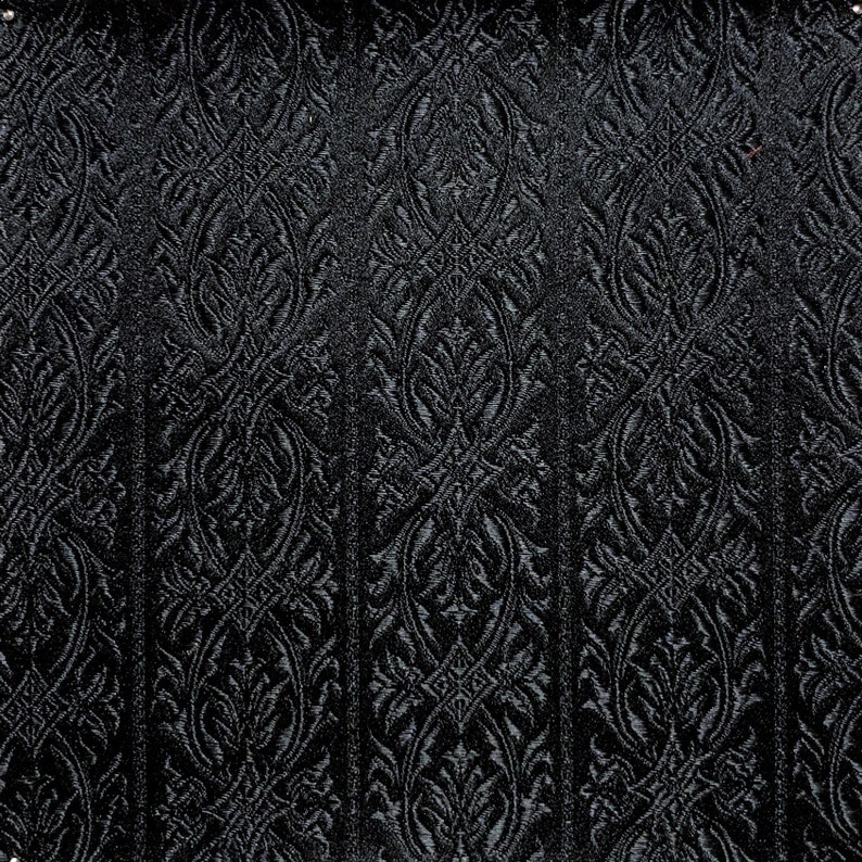 May include: Black fabric with a raised, embossed damask pattern. The pattern is a repeating design of stylized leaves and swirls.