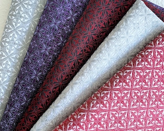 May include: Five fabric swatches with a repeating geometric pattern. The swatches are in shades of red, purple, and gray.