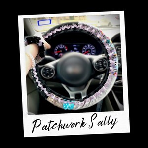 May include: A close-up of a car steering wheel with a colourful patchwork fabric cover. The cover has a light purple, black and white base with a blue and white bow. The text "Patchwork Sally" is written below the steering wheel.