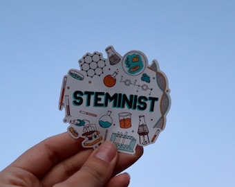 May include: A white sticker with a blue and black word "STEMINIST" surrounded by science-related illustrations, including a microscope, beakers, test tubes, and a DNA strand.