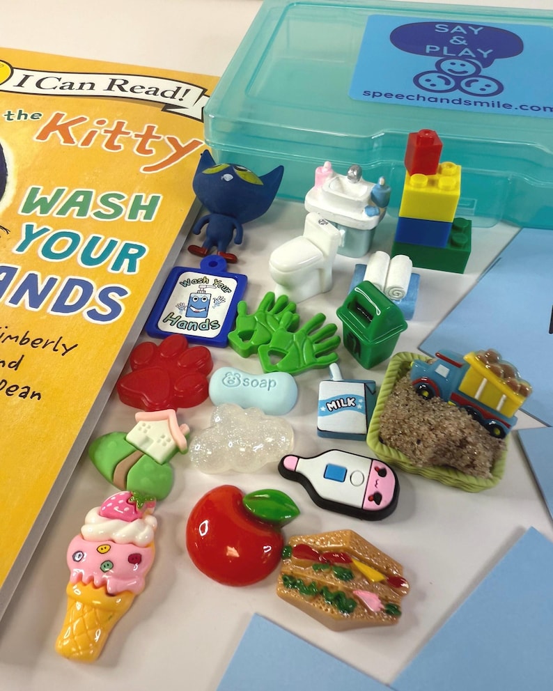 May include: A collection of colorful, miniature toy figures and accessories, including a book titled "The Kitty Wash Your Hands". The toys include a blue cat figure, a miniature toilet, a stack of blocks, and a toy train.