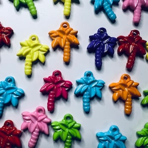 May include: Assortment of colorful palm tree charms, each with a different color and design. The charms are made of plastic and have a hole at the top for attaching to a necklace, bracelet, or other jewelry.
