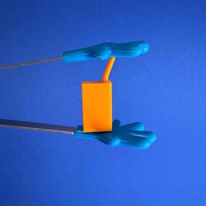 May include: An orange rectangular object with a curved orange tube is held between two blue hand-shaped grips. The grips are attached to silver metal rods. The background is a solid blue.