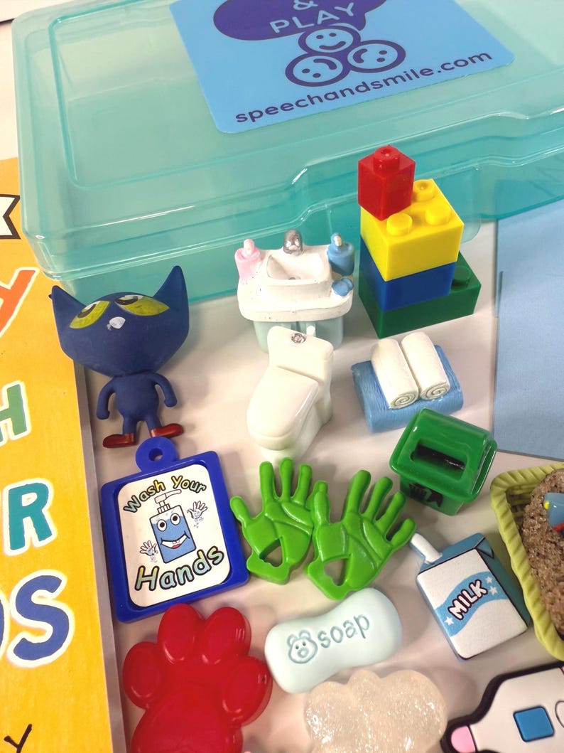 May include: A collection of colorful toy figures and accessories, including a blue cat, a miniature sink, a toilet, a stack of blocks, green gloves, and a sign that says "Wash Your Hands". A blue plastic container is in the background.