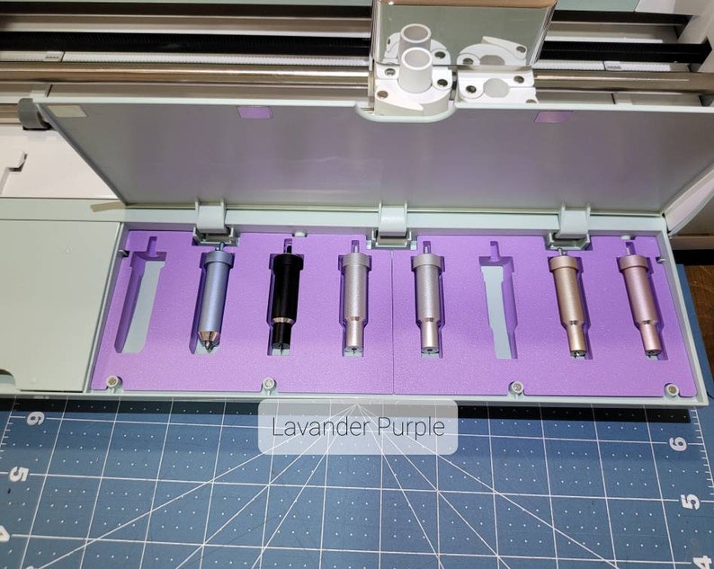Pode incluir: Um close-up de uma bandeja de espuma roxa com seis l&acirc;minas de corte de diferentes cores para uma m&aacute;quina de corte artesanal. As l&acirc;minas s&atilde;o etiquetadas como "Lavender Purple".