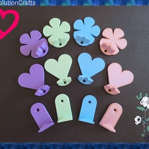 May include: Assortment of wooden wall hooks in various shapes and colors, including hearts and flowers. The hooks are painted in pastel shades of purple, pink, blue, and green.
