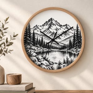 May include: A round wall clock with a light wood frame featuring a black and white illustration of a mountain range, a dense pine forest, and a calm lake in the foreground. The clock has black hour, minute, and second hands centered on the dial.
